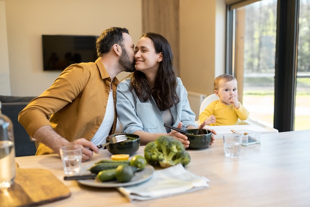 Junge Familie mit einem einjährigen Jungen während einer Mittagspause zu Hause