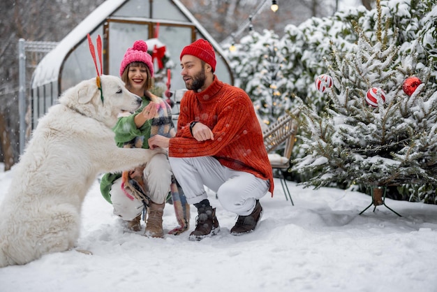 Junge Familie mit Hund im verschneiten Hinterhof während der Winterferien