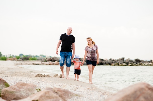 junge Familie mit ihrem Sohn auf dem Meer spazieren