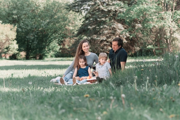 Junge Familie mit Kindern, die am Vesani-Tag auf dem Rasen sitzen