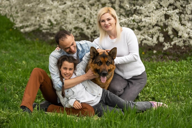 Junge Familie mit Kindern und mit Hund, die Spaß in der Natur haben