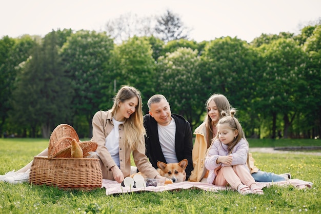 Junge Familie und ihr Corgi-Hund beim Picknick in einem Park