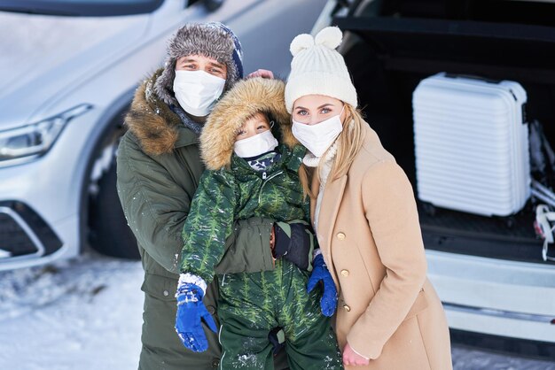 Junge Familie während der Winterreise Kofferraum im Hintergrund. Foto in hoher Qualität