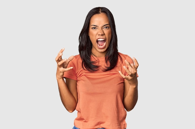 Junge Filipina mit langen schwarzen Haaren im Studio schreit vor Wut