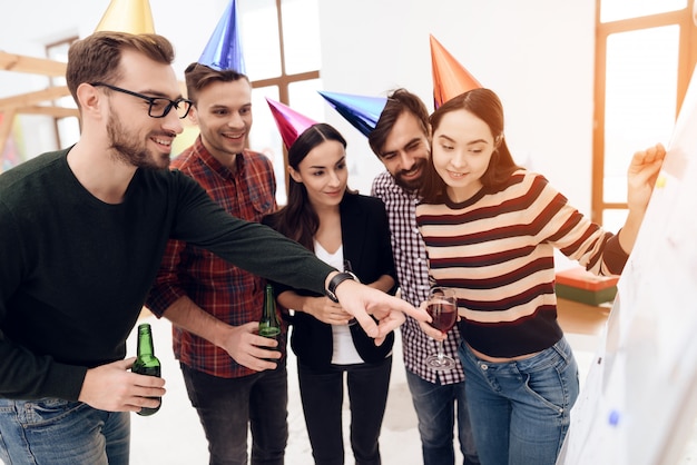 Junge Firmenangestellte unterhalten sich in der Nähe einer Tafel.