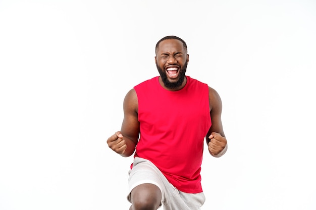 Junge Fitness afrikanischer schwarzer Mann in Sportkleidung jubelt sorglos und aufgeregt. Sieg-Konzept.