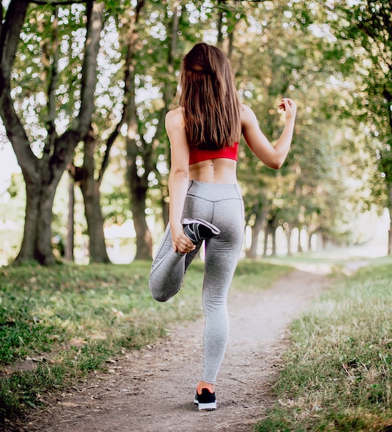 Foto junge fitnessfrau, die im park ausübt