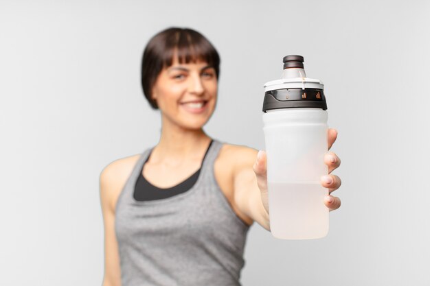 Junge Fitnessfrau mit einer Wasserkanne