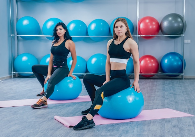 Junge Fitnessfrauen mit blauen Fitballs. Crossfit-Training.