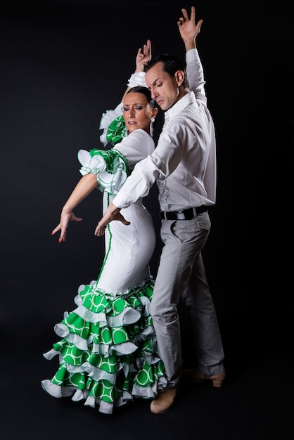 Junge flamenco-tänzer in schönen kleid auf schwarzem hintergrund.