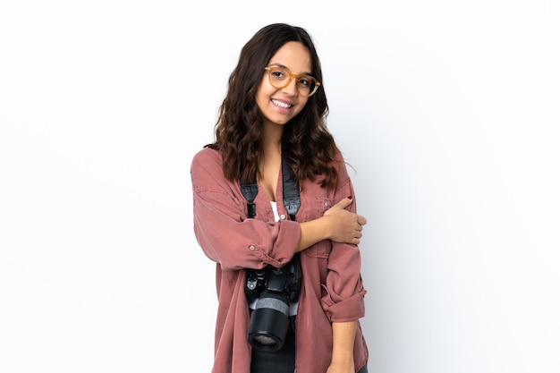 Junge Fotograffrau über isoliertem weißem Wandlachen