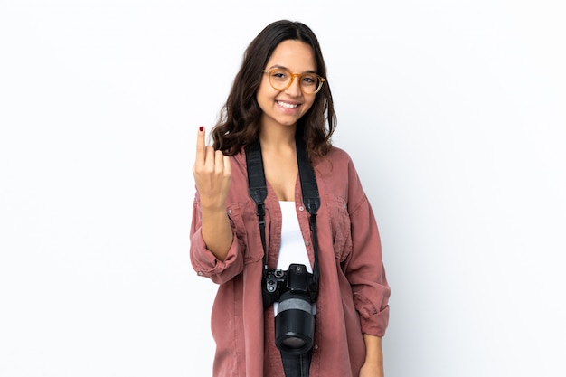 Junge Fotograffrau über weißer Wand, die kommende Geste tut