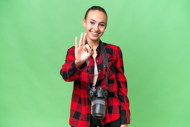 Junge Fotografin, arabische Frau mit isoliertem Hintergrund, glücklich und mit den Fingern drei zählend