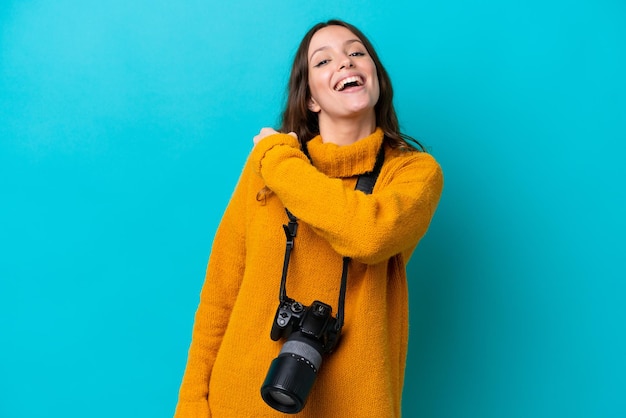 Junge Fotografin isoliert auf blauem Hintergrund, die einen Sieg feiert