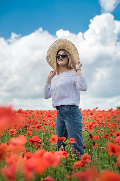 Junge Frau allein am Mohn im Feldsommertag