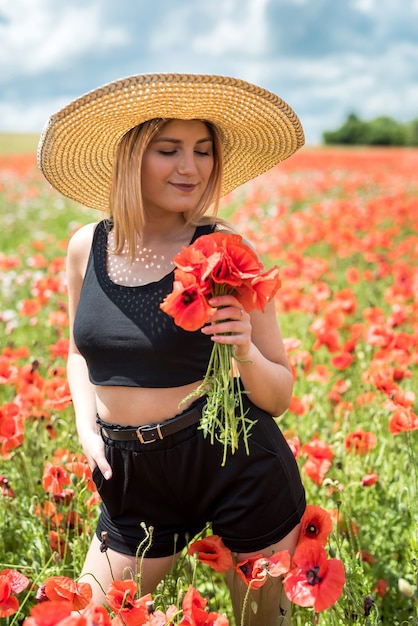 Junge Frau allein am Mohn im Feldsommertag