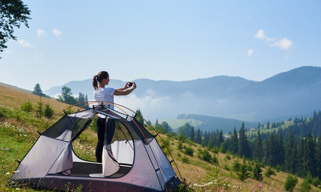 Junge Frau am kleinen Touristenzelt