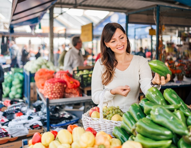 Junge frau am lokalen lebensmittelmarkt.