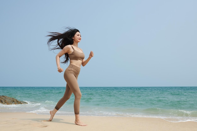 Junge Frau am Strand joggen