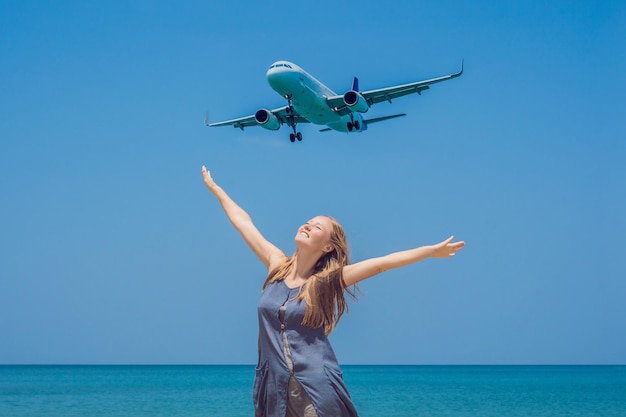 Junge Frau am Strand und Landungsflugzeuge. Reisekonzept.