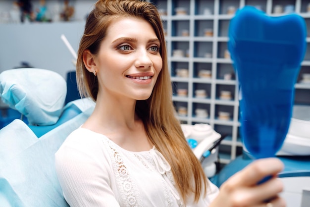 Junge Frau am Zahnarztstuhl während eines zahnärztlichen Eingriffs Überblick über die Vorbeugung von Zahnkaries