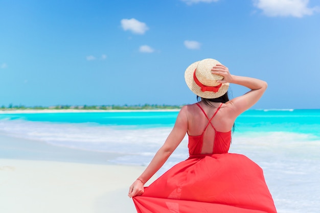 Junge Frau an einem tropischen Strand mit Hut