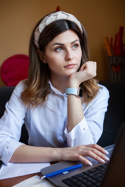 Junge Frau arbeitet am Computer in einem Café