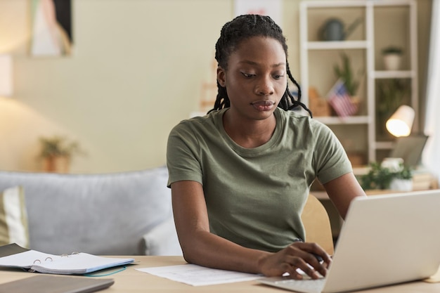 Junge Frau arbeitet online am Laptop