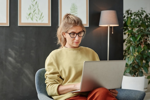 Junge Frau arbeitet online am Laptop