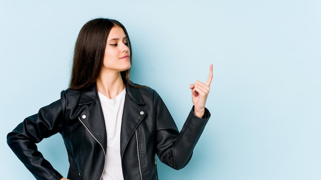 Junge Frau auf Blau zeigt mit dem Finger auf Sie, als ob die Einladung näher kommt.