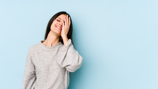 Junge Frau auf blauem Lachen glücklich, sorglos, natürliches Gefühl.