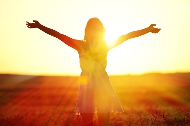 Foto junge frau auf dem feld im abendlicht