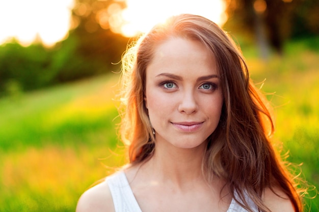 Junge Frau auf dem Feld unter Abendlicht