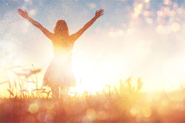 Junge Frau auf dem Feld unter Abendlicht