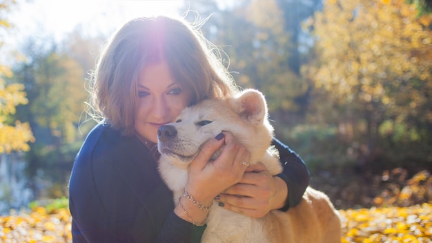 Junge Frau auf einem Spaziergang mit ihrer Hunderasse Akita inu