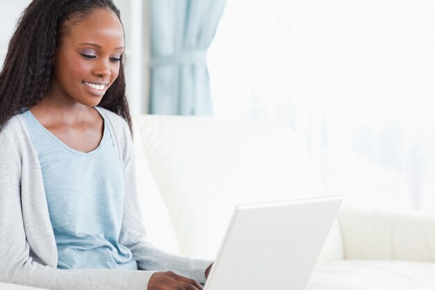 Junge Frau auf Sofa mit Laptop