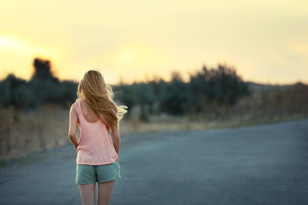 Foto junge frau auf sonnenuntergang himmelshintergrund