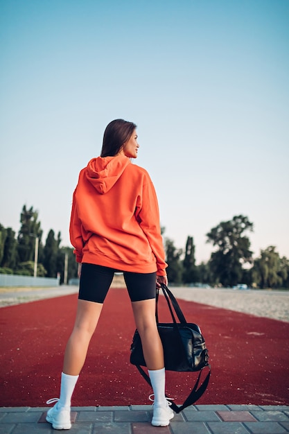 Junge Frau auf Sportplatz, die sich auf Fitness vorbereitet