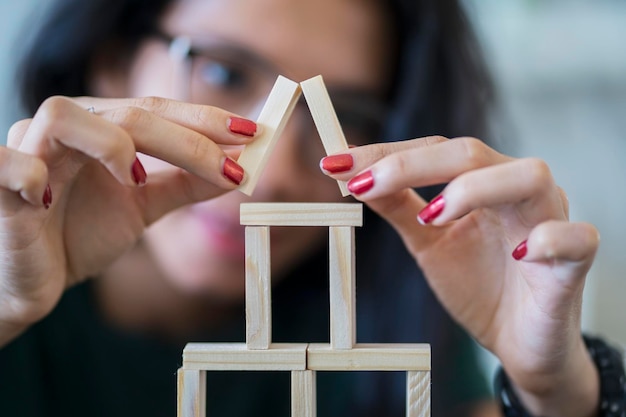 Junge Frau baut ein Haus mit Bauklötzen