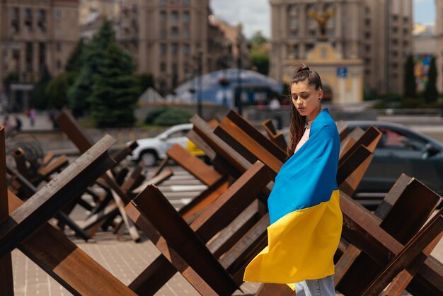 Junge Frau bedeckt mit der ukrainischen Flagge