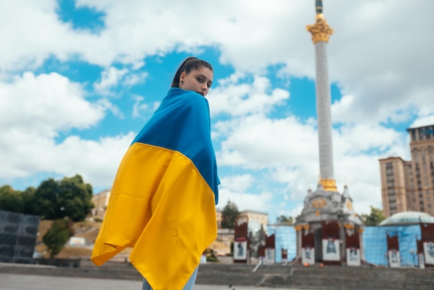 Junge Frau bedeckt mit der ukrainischen Flagge