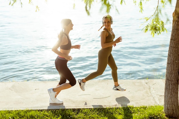 Junge Frau beim Lauftraining an der Flusspromenade