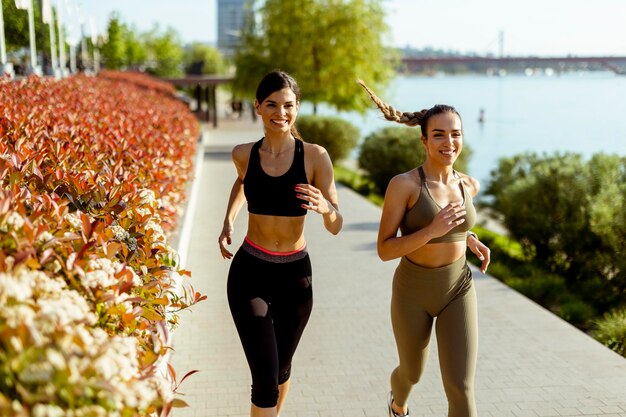 Junge Frau beim Lauftraining an der Flusspromenade