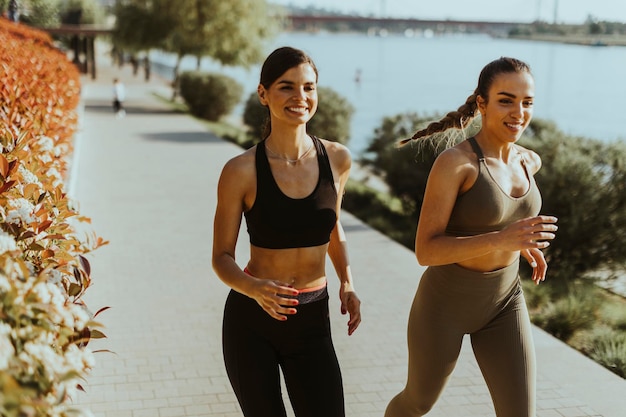 Junge Frau beim Lauftraining an der Flusspromenade