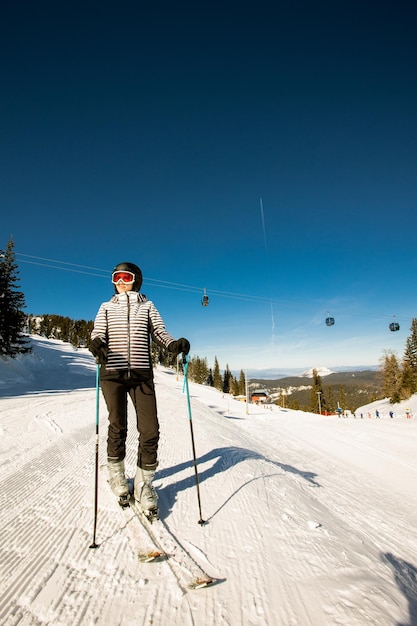 Junge Frau beim Winterskifahren vergnügt sich mit einem Abenteuer an einem sonnigen Tag