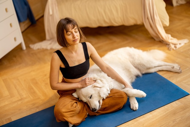 Junge Frau beim Yoga mit ihrem Hund