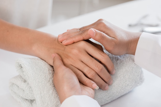 Foto junge frau bekommt eine handmassage mit kosmetikerin