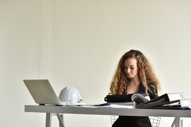 Foto junge frau benutzt das telefon, während sie auf dem tisch sitzt