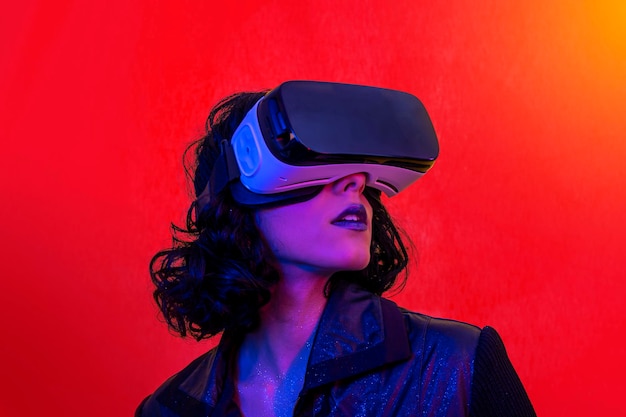 Junge Frau benutzt das Virtual-Reality-Headset, ein modernes Porträt mit trendigem Aussehen und hellen Farben