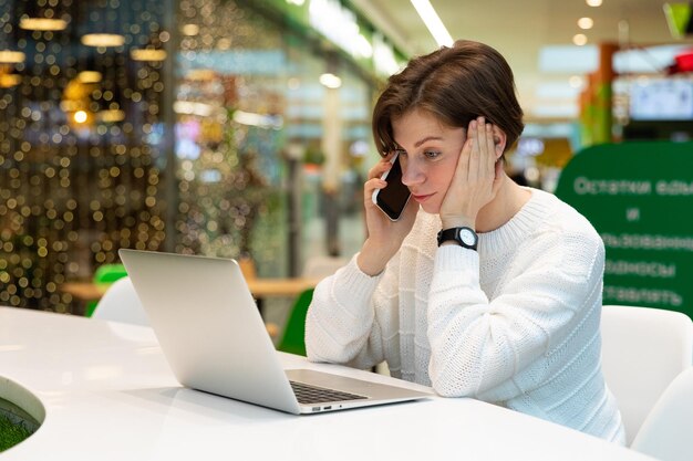 Foto junge frau benutzt laptop im café